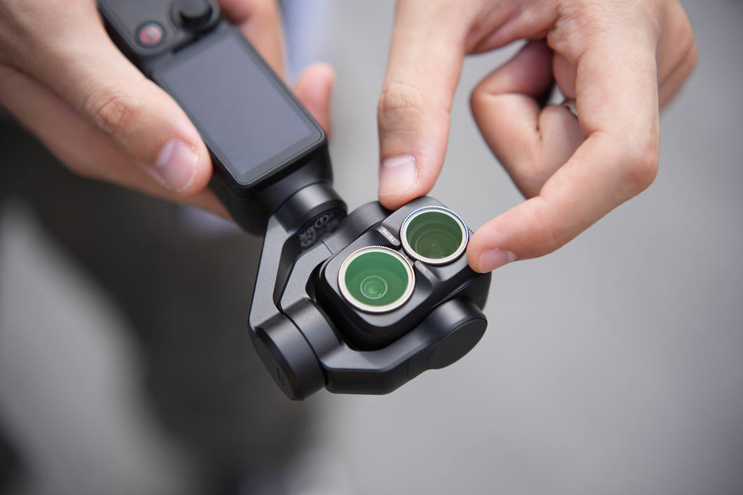 Händer som klickar fast ett NiSi-filter på kamerahuvudet på en DJI Osmo Pocket 4 Pro